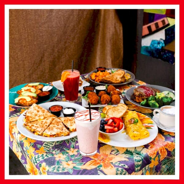 A table laden with various dishes, including quesadillas, fried appetizers, omelets, and drinks.